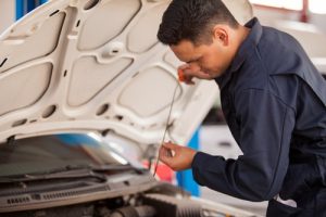 Handsome,Latin,Mechanic,Measuring,The,Oil,Level,Of,An,Engine - Meineke Massachusetts Oil Change | Meineke Car Care | Lowell, MA
